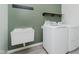 Functional laundry room with new appliances, a sink, and minimalist shelving at 7724 Dunleer Dr, Brownsburg, IN 46112