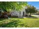 Spacious backyard with lush green lawn, a playset, and the white brick house with steps to the front door at 8 W Jackson St, Knightstown, IN 46148
