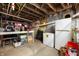 Unfinished basement with storage shelves, refrigerator, and concrete floor at 8 W Jackson St, Knightstown, IN 46148