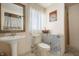Bathroom featuring a white pedestal sink, toilet with decorative tile, and natural light at 8 W Jackson St, Knightstown, IN 46148