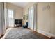 Well-lit bedroom with striped wallpaper, decorative game wall art, and hardwood floors at 8 W Jackson St, Knightstown, IN 46148