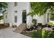 Side view of a white brick home with a stone staircase and beautifully landscaped garden area at 8 W Jackson St, Knightstown, IN 46148