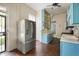 Kitchen with custom blue cabinets, stainless steel refrigerator, and dark hardwood floors at 8 W Jackson St, Knightstown, IN 46148