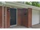 Close up image showing the address of a brick home, front door, and a white garage at 8109 E Penway St, Indianapolis, IN 46226