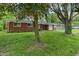 Picture of a single story brick house with a black roof, a garage, and a tree at 8109 E Penway St, Indianapolis, IN 46226
