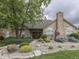 Clubhouse exterior with a manicured landscape and stone facade under a cloudy sky at 811 Gazebo Way, Greenwood, IN 46142