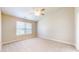Bright bedroom features neutral carpet, lighted ceiling fan, and a window for natural light at 8121 Sand Ridge Cir, Indianapolis, IN 46237