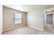 Carpeted bedroom features a window for natural light and a door for easy access at 8121 Sand Ridge Cir, Indianapolis, IN 46237