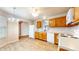 Well-lit kitchen with laminate floors, wood cabinets, white appliances, and a dining area at 8121 Sand Ridge Cir, Indianapolis, IN 46237