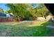 Grassy backyard with mature trees, fenced perimeter, and storage sheds at 8744 Montery Ct, Indianapolis, IN 46226