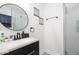 Modern bathroom features a stylish black vanity, round mirror, and glass shower at 8744 Montery Ct, Indianapolis, IN 46226