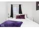 Bright bedroom showcasing plush purple accents, white nightstands, and soft natural light at 8744 Montery Ct, Indianapolis, IN 46226