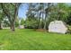 Large backyard featuring lawn, mature trees, and outbuildings at 8752 Washington Blvd E Dr, Indianapolis, IN 46240