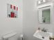 Bright half bathroom with sink and toilet accented by colorful decorative artwork on the wall at 8752 Washington Blvd E Dr, Indianapolis, IN 46240