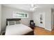 This bright bedroom is furnished with a ceiling fan, a plush chair and ottoman, and a mirrored sliding closet at 8752 Washington Blvd E Dr, Indianapolis, IN 46240