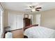 Comfortable bedroom featuring wood floors, a ceiling fan, and an expansive closet for ample storage space at 8752 Washington Blvd E Dr, Indianapolis, IN 46240