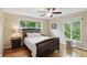 Bedroom with a large window, hardwood floors, ceiling fan, and traditional-style furniture and furnishings at 8752 Washington Blvd E Dr, Indianapolis, IN 46240