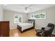 Inviting bedroom with wood flooring, chair, ceiling fan, and natural light from the large windows at 8752 Washington Blvd E Dr, Indianapolis, IN 46240
