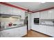 Well-lit kitchen with stainless steel appliances, white cabinets, and a view into another room at 8752 Washington Blvd E Dr, Indianapolis, IN 46240