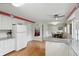 Open kitchen floorplan featuring white cabinets, stainless appliances, and a view into the dining area at 8752 Washington Blvd E Dr, Indianapolis, IN 46240
