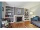 Cozy living room with a fireplace, built-in shelving, hardwood floors, and comfortable seating at 8752 Washington Blvd E Dr, Indianapolis, IN 46240
