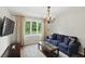 Cozy living room featuring a blue sofa, chandelier, and large window with a view of the outdoors at 8752 Washington Blvd E Dr, Indianapolis, IN 46240