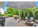 Large backyard with stone patio including shade cover, dining area, and firepit at 8973 Carnation Dr, Noblesville, IN 46060
