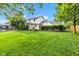 Expansive green lawn with mature trees, covered patio, and landscape at 8973 Carnation Dr, Noblesville, IN 46060