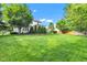 Large lawn with mature trees, backyard patio, and landscape at 8973 Carnation Dr, Noblesville, IN 46060