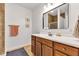 Bathroom featuring a cherry vanity, modern sink, large mirror, and tiled shower at 8973 Carnation Dr, Noblesville, IN 46060