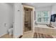 Tiled bathroom with tiled walk-in shower with glass door and bright tub at 8973 Carnation Dr, Noblesville, IN 46060