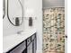 This updated bathroom boasts a modern vanity, sleek oval mirrors, and a charming fish themed shower curtain at 8973 Carnation Dr, Noblesville, IN 46060