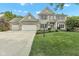 Charming two-story brick home featuring a three-car garage, landscaped yard, and manicured lawn at 8973 Carnation Dr, Noblesville, IN 46060