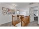 Upstairs hallway featuring a wood railing, carpet, and a gallery wall with assorted artwork at 8973 Carnation Dr, Noblesville, IN 46060