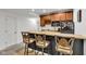 Finished basement kitchenette featuring cherry cabinets, a wine rack, and breakfast bar seating at 8973 Carnation Dr, Noblesville, IN 46060