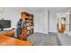 Corner view of a home office, featuring a desk, bookcase, and sitting area with a gray sofa at 8973 Carnation Dr, Noblesville, IN 46060
