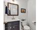 Stylish powder room with a blue vanity, white countertop, decorative mirror, and toilet at 8973 Carnation Dr, Noblesville, IN 46060