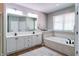 A well-lit main bathroom featuring double sinks and a large soaking tub at 9154 Sargent Manor Ct, Indianapolis, IN 46256