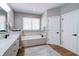Bright bathroom featuring a tiled tub, modern fixtures, and neutral color palette at 9154 Sargent Manor Ct, Indianapolis, IN 46256