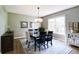 Traditional dining room features a dark wood table, modern chandelier, and large windows for ample natural light at 9154 Sargent Manor Ct, Indianapolis, IN 46256