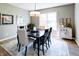 Dining room features a dark wood table, modern lighting, and a large window for natural light at 9154 Sargent Manor Ct, Indianapolis, IN 46256