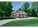 Beautiful two-story brick home featuring a well-manicured lawn, lush landscaping, and a basketball hoop at 9154 Sargent Manor Ct, Indianapolis, IN 46256