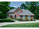 Beautiful two-story brick home featuring a well-manicured lawn, lush landscaping, and a circular driveway at 9154 Sargent Manor Ct, Indianapolis, IN 46256