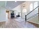 Bright foyer featuring hardwood floors, a chandelier, a staircase, and views into the dining room at 9154 Sargent Manor Ct, Indianapolis, IN 46256