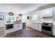 Bright kitchen features white cabinets, stainless appliances, island with seating, and modern pendant lighting at 9154 Sargent Manor Ct, Indianapolis, IN 46256