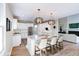 Bright open kitchen boasts stainless appliances, white cabinetry, an island with seating, and modern pendant lighting at 9154 Sargent Manor Ct, Indianapolis, IN 46256