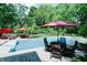 A private backyard features an in-ground pool with patio and lounge areas beneath colorful umbrellas at 9154 Sargent Manor Ct, Indianapolis, IN 46256