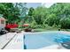 A private backyard features an in-ground pool and lounge seating under vibrant umbrellas at 9154 Sargent Manor Ct, Indianapolis, IN 46256