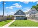 Spacious backyard featuring a well-manicured lawn and a charming blue house on a sunny day at 1015 N Beville Ave, Indianapolis, IN 46201