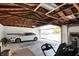 Spacious garage featuring exposed wood rafters, an open door, and ample parking space for one car at 1015 N Beville Ave, Indianapolis, IN 46201